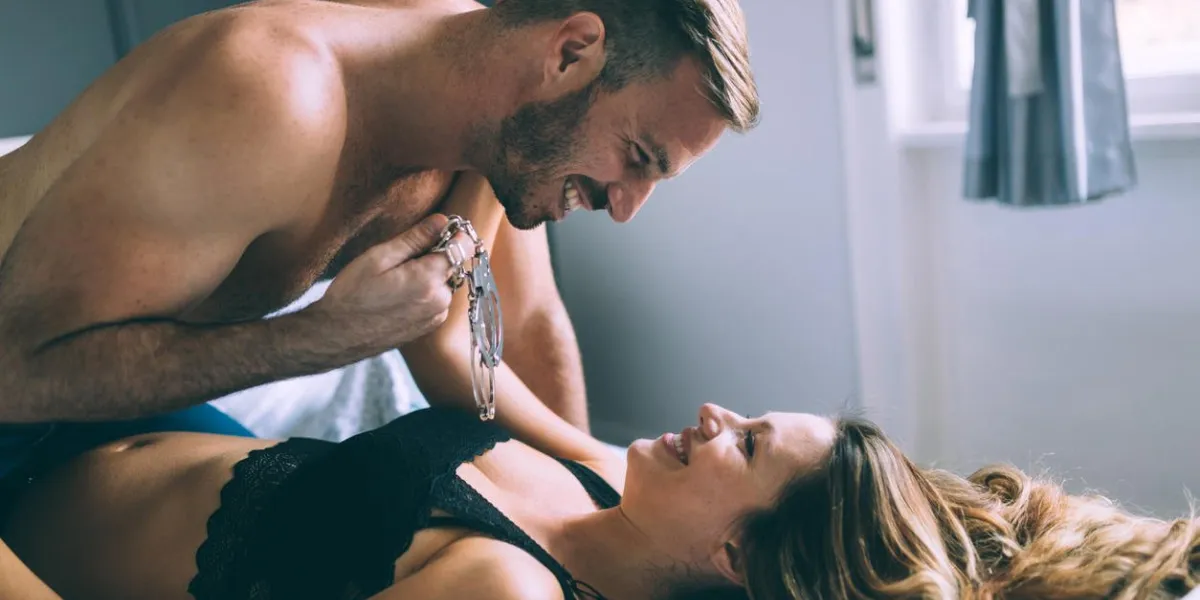 woman and man playing domination games in bed together