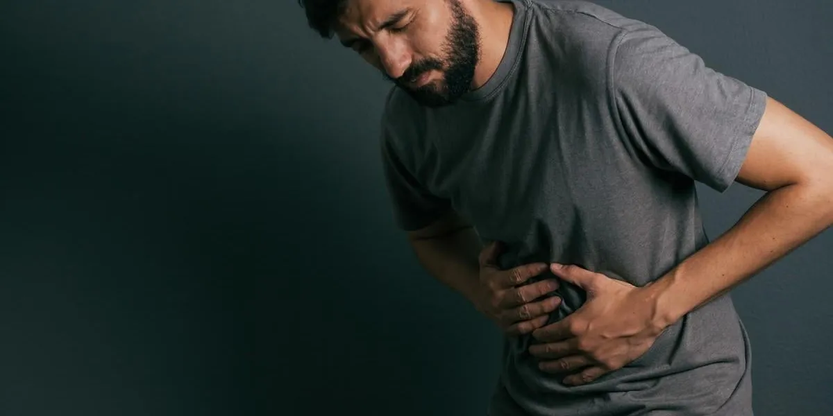 young man suffering from stomach ache standing