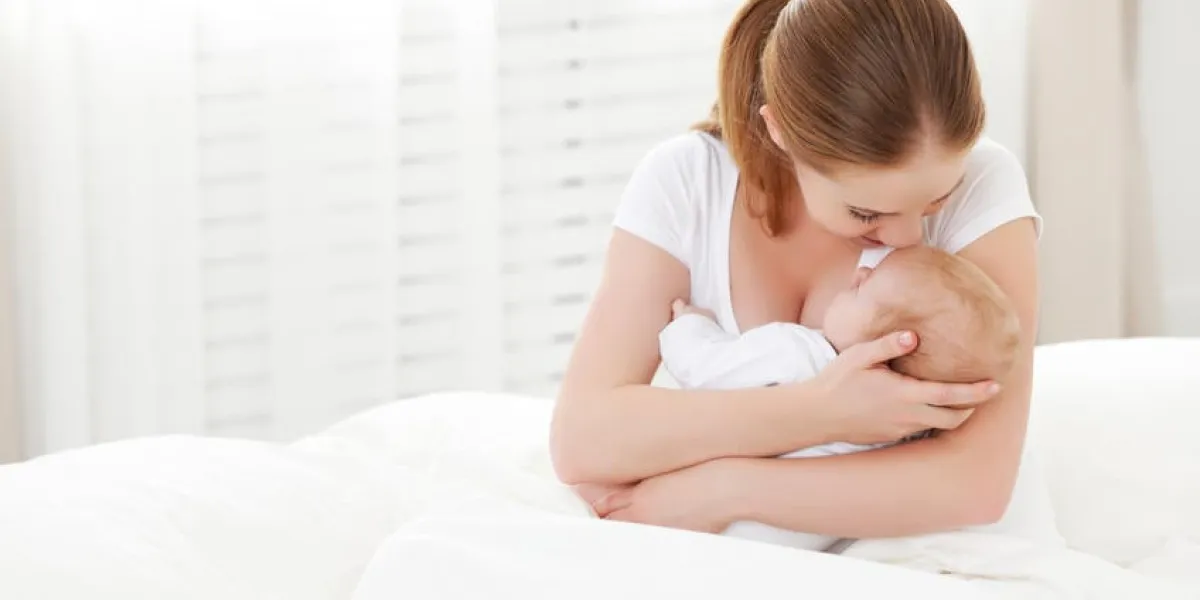 heureuse famille nouveau-né dans une étreinte sa mère dans un lit blanc