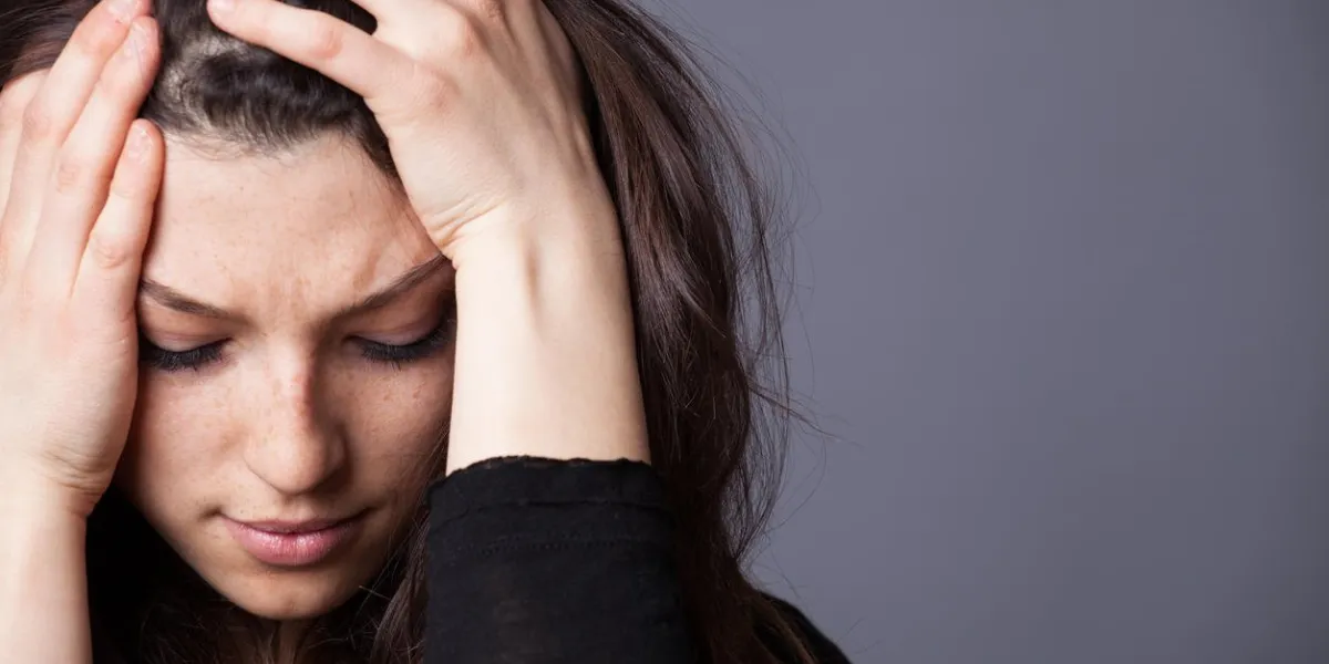 young sad girl with her hands on her head