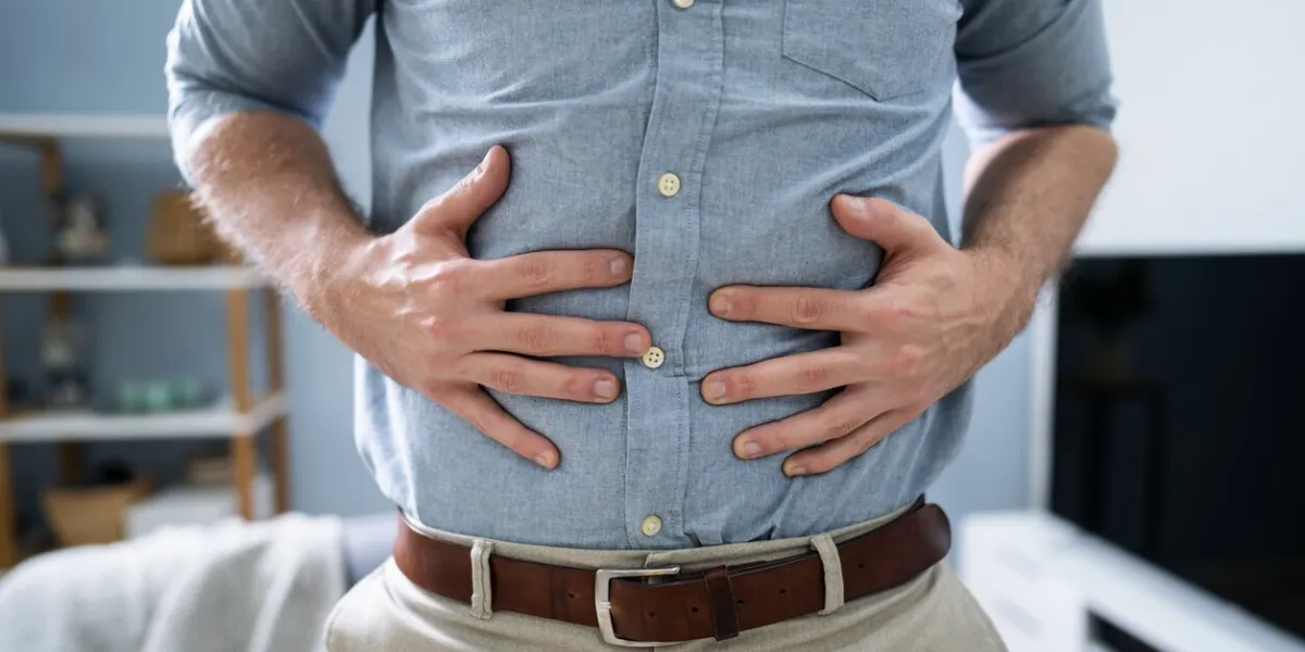 man with stomach ache standing at home