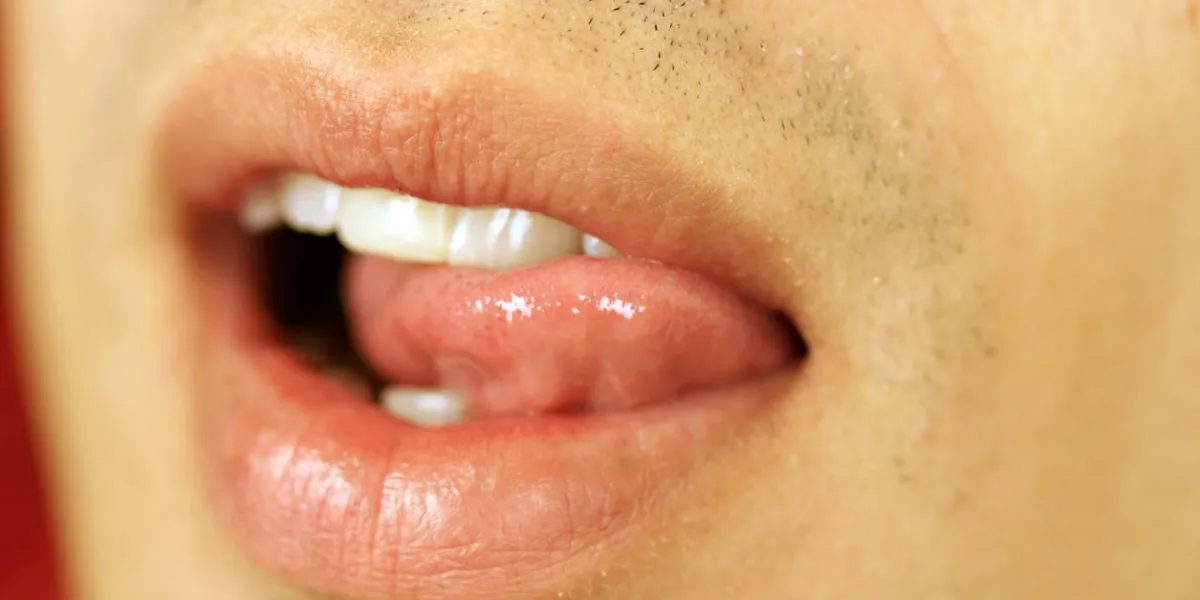 a close up of a human mouth and lips with tongue