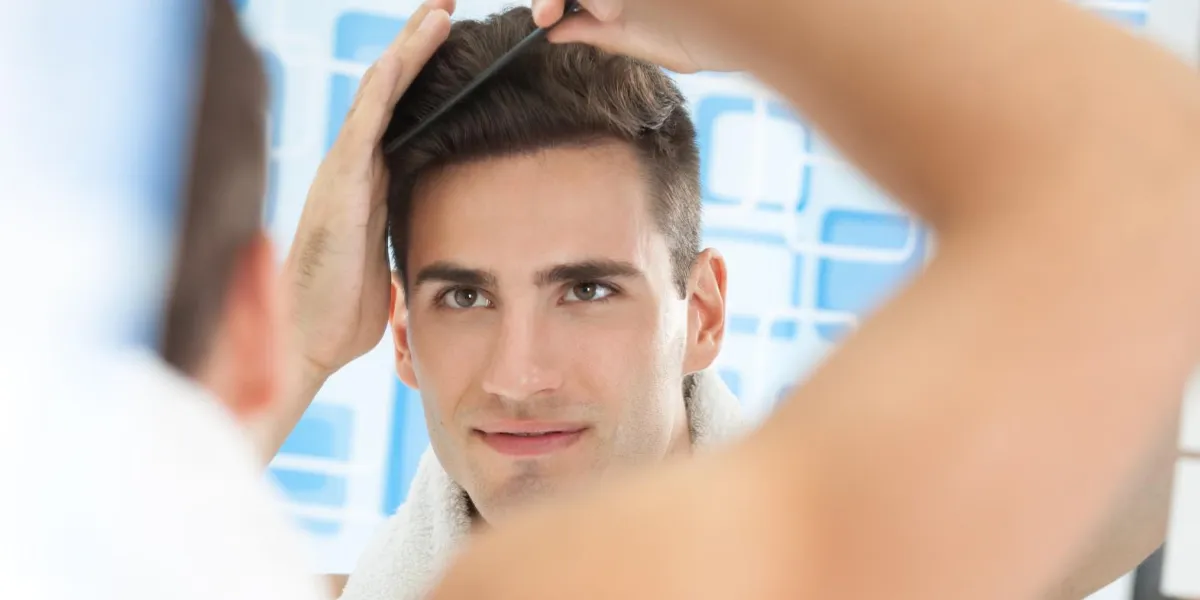 peignes de jeune homme beau dans la salle de bain