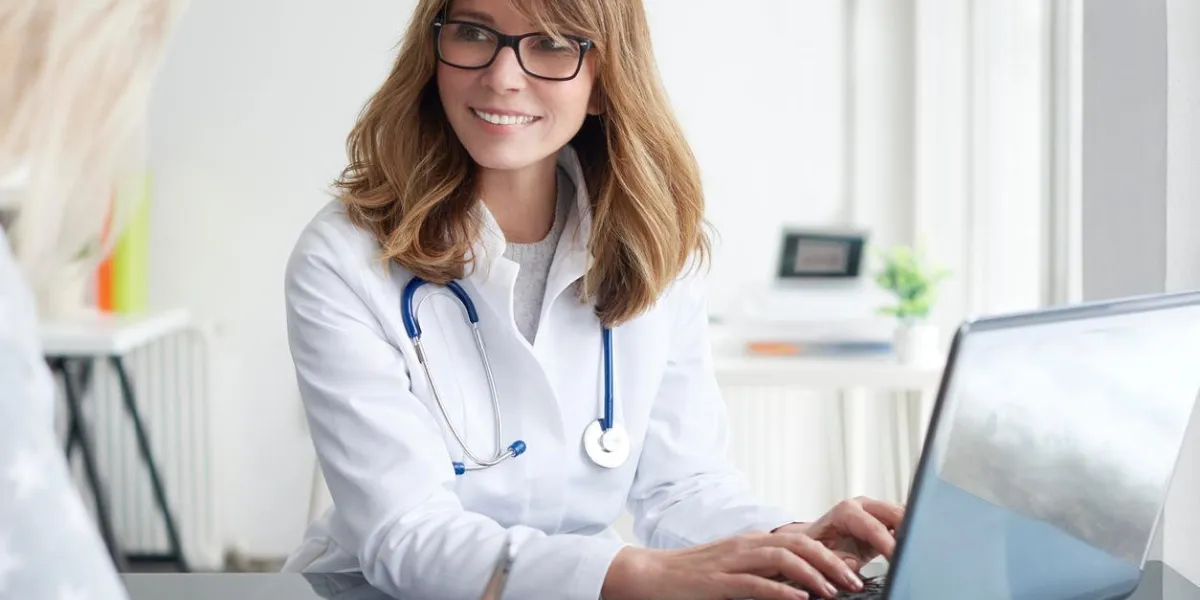 shot of a middle aged female doctor sitting in front of laptop and consulting with her patient