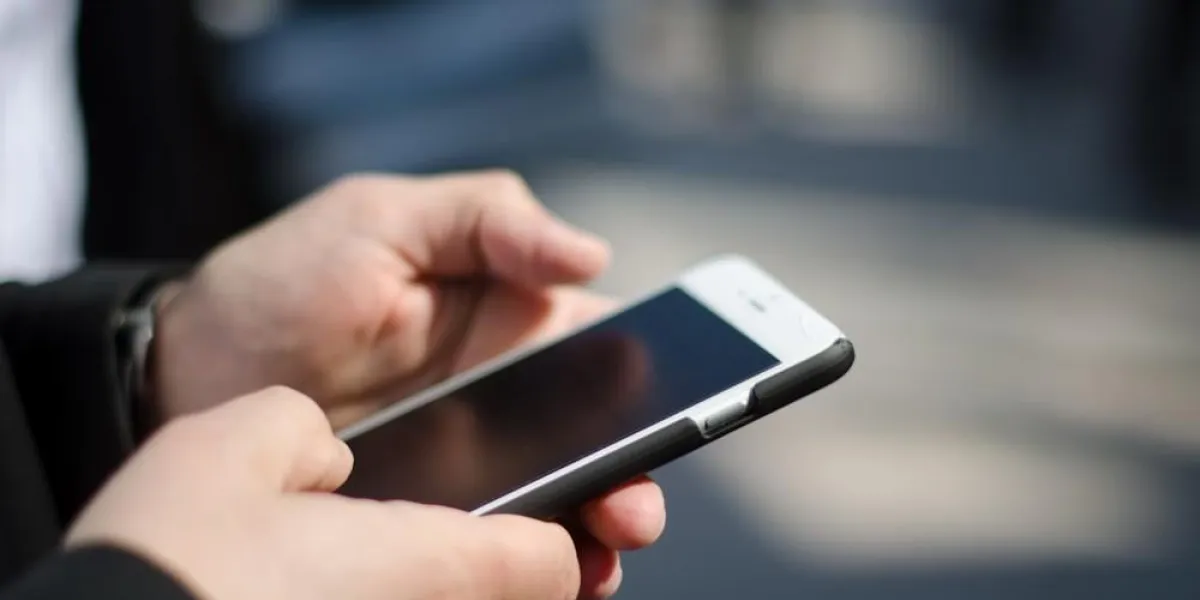 uomo business scrive mail su cellulare