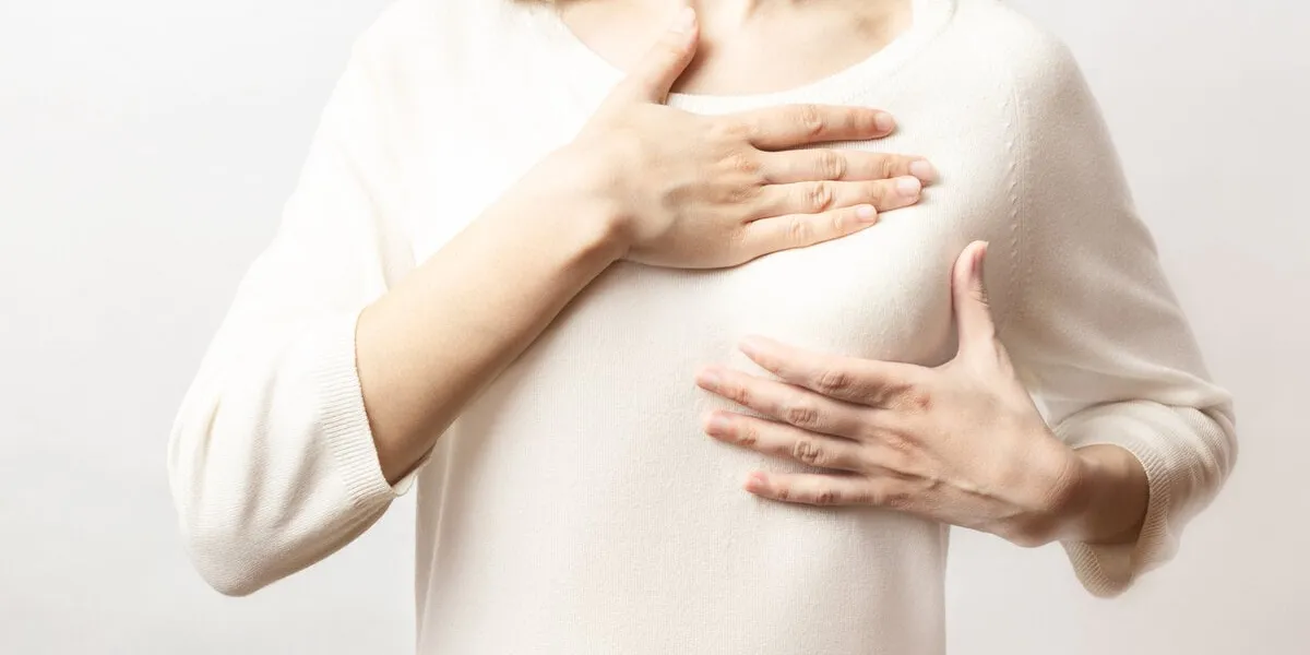 woman hand checking lumps on her breast for signs of breast cancer on white background healthcare concept cancer self check, healthy girl