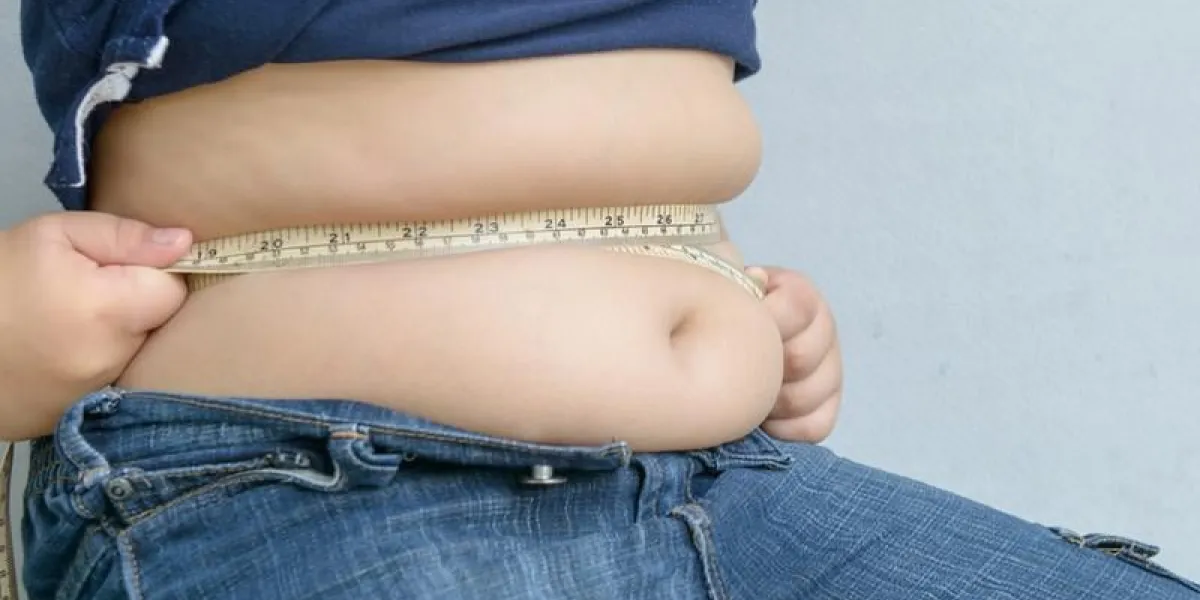 gros garçon mesurant son ventre avec du ruban de mesure