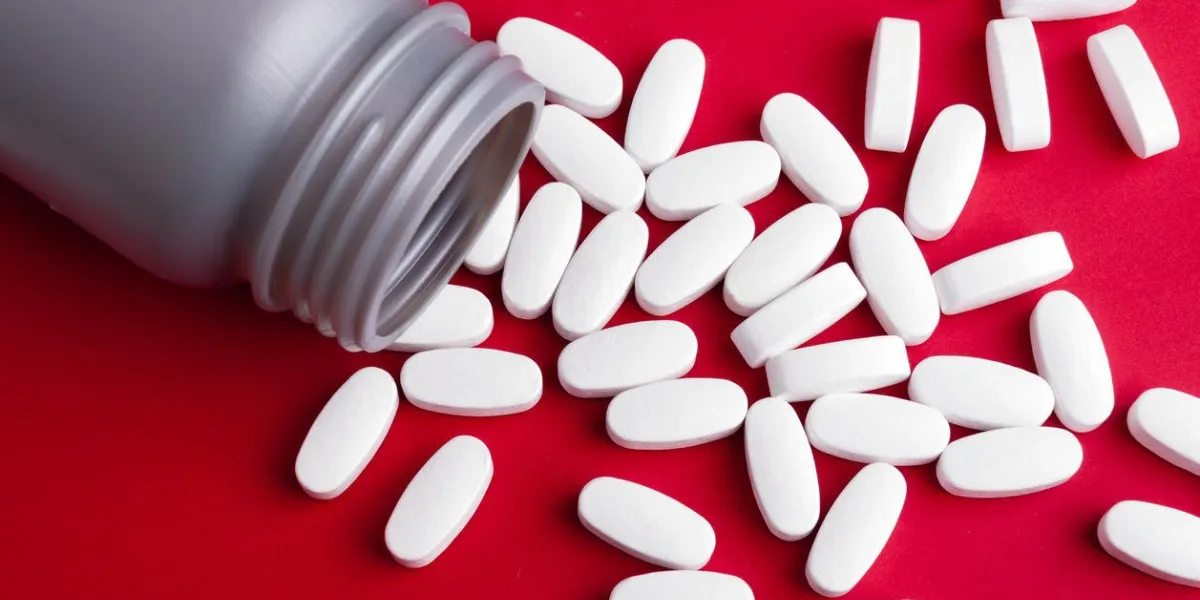 fermer le récipient de la médecine en comprimés sur fond rouge