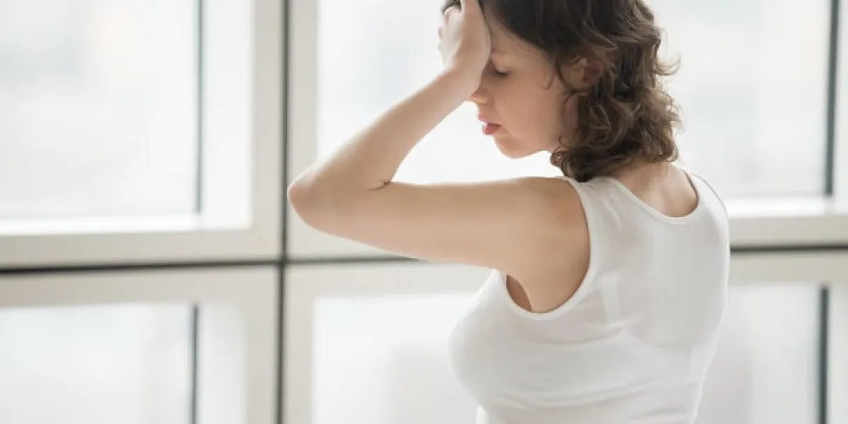 portrait de profil de jeune femme séduisante touchant son front, souffrant de maux de tête ou de manque de sommeil à l'intérieur