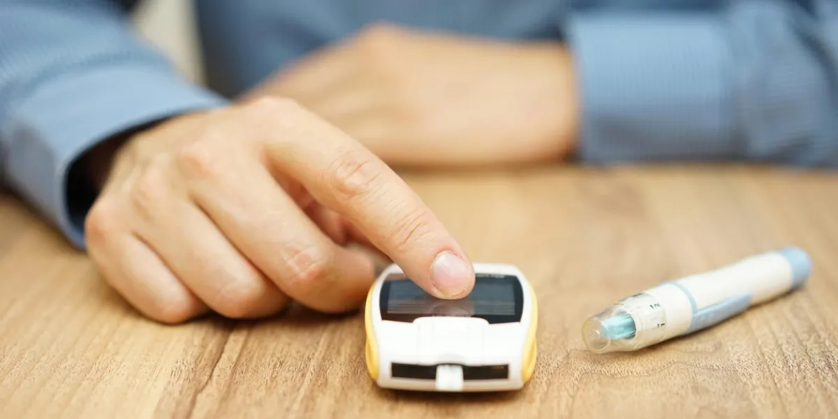 homme testant le niveau de glucose avec un glucomètre numérique, traitement du diabète