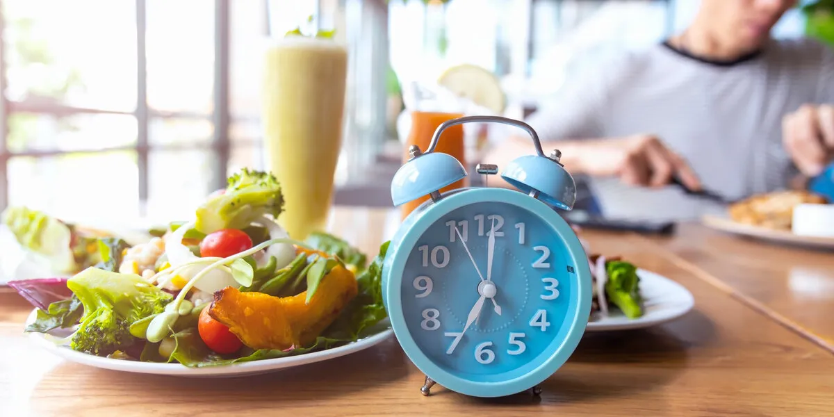 blue alarm clock with if (intermittent fasting) 16 and 8 diet rule and weight loss concept-diet plan concept