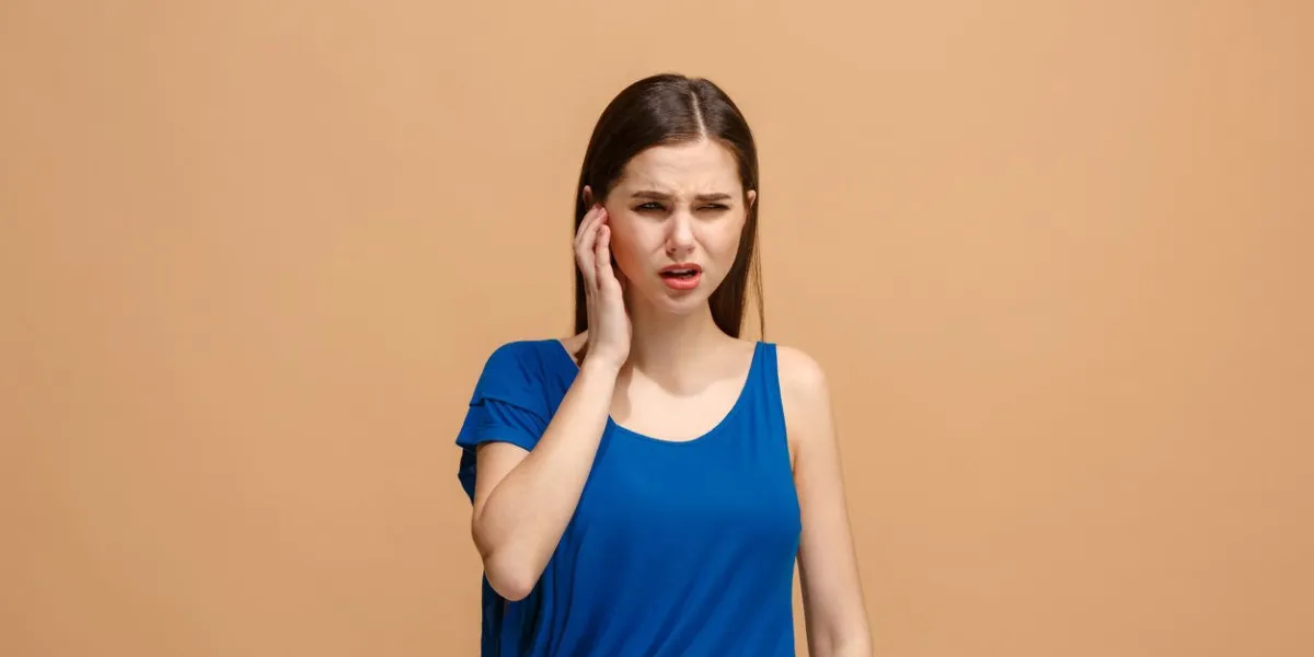 sore ear ear ache concept the sad crying woman with headache or pain on trendy pastel studio background facial expressions and people emotions concept front view half-length front portrait young woman