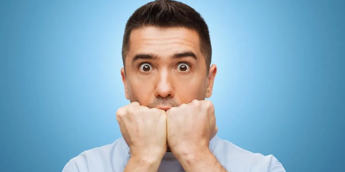 concept de peur, d'horreur, d'émotions et de personnes - visage d'homme effrayé sur fond bleu