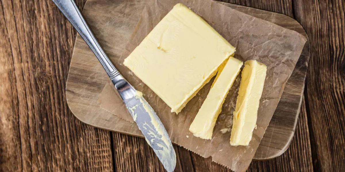 portion de beurre frais (mise au point sélective, gros plan) sur fond en bois