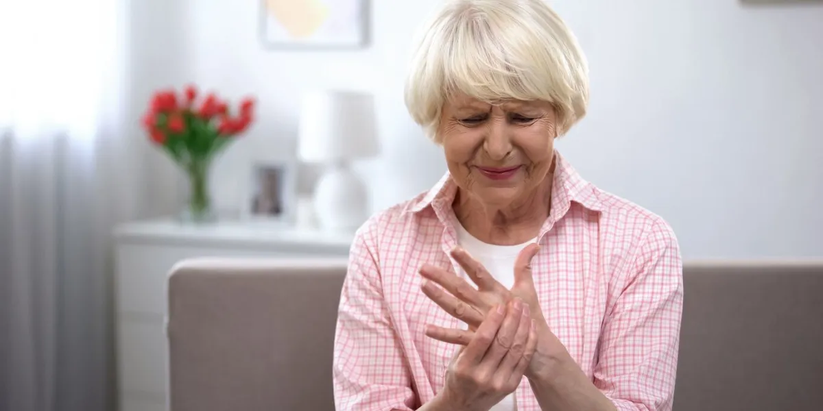 upset old woman suddenly feeling sharp pain in wrist, arthritis health problem