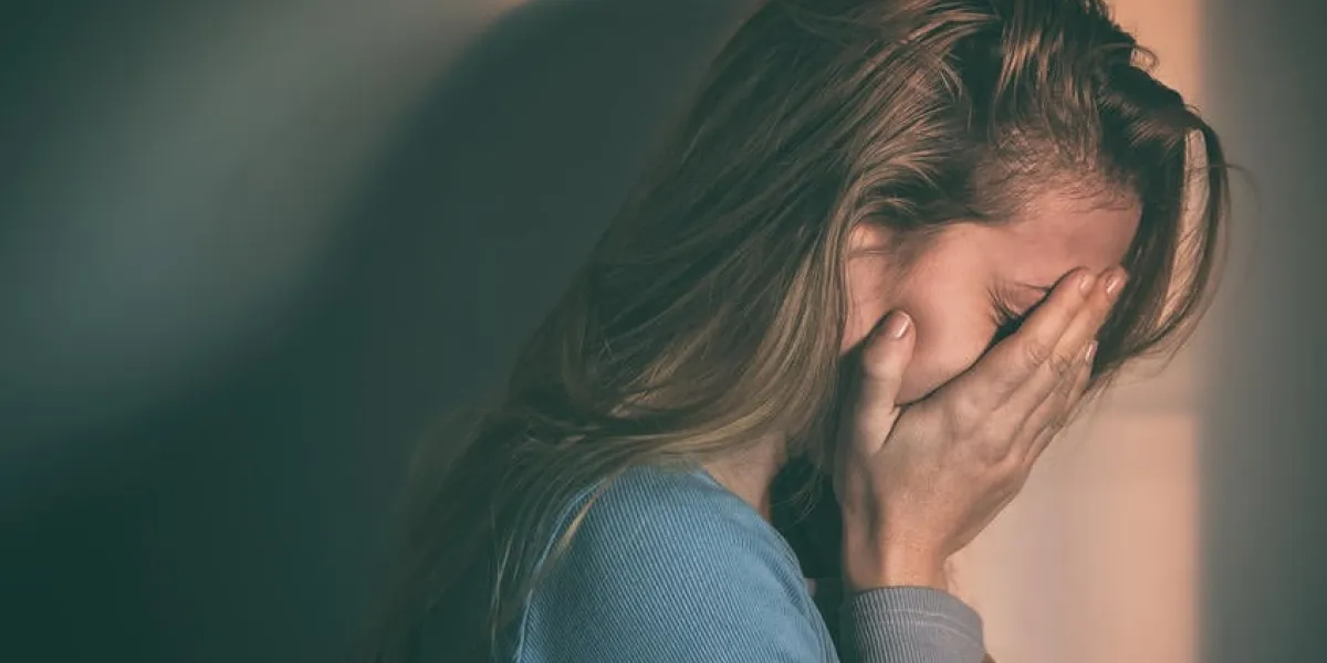 une femme assise seule et déprimée au coucher du soleil