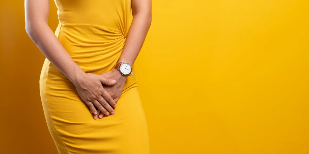 closeup sick woman with hands holding pressing her crotch isolated on background