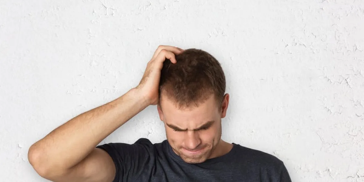 jeune et bel homme pensant à problème avec fond rugueux fissuré