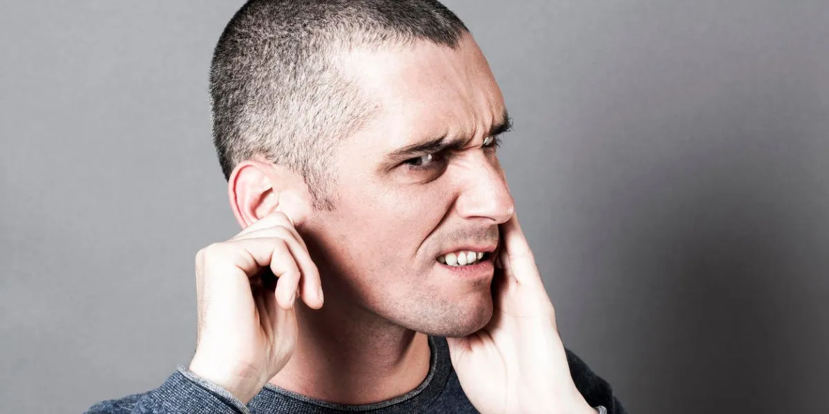 concept de bruit et d'audition - pensée jeune homme souffrant d'otalgie ou de mal de dents, toucher son visage pour la douleur, les effets de contraste