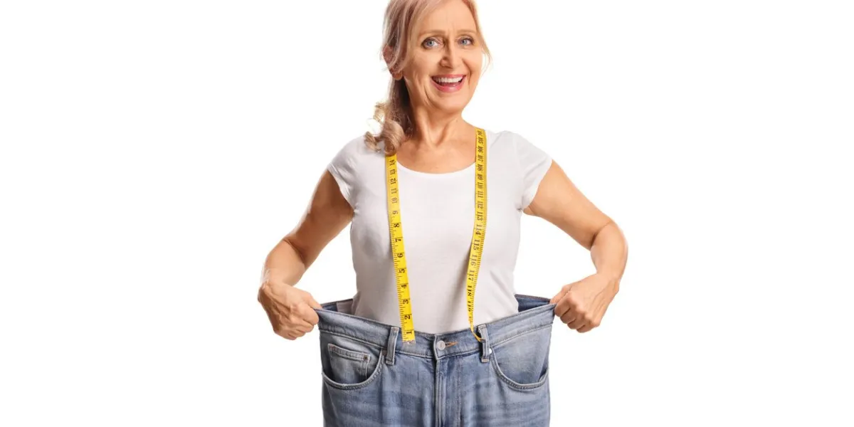 mature woman in oversized jeans and weight loss concept isolated on white background