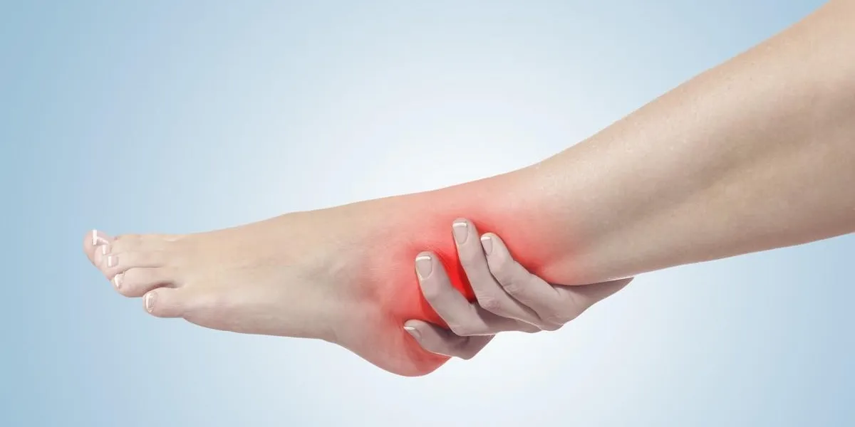 a young woman massaging her painful ankle medicine concept photo