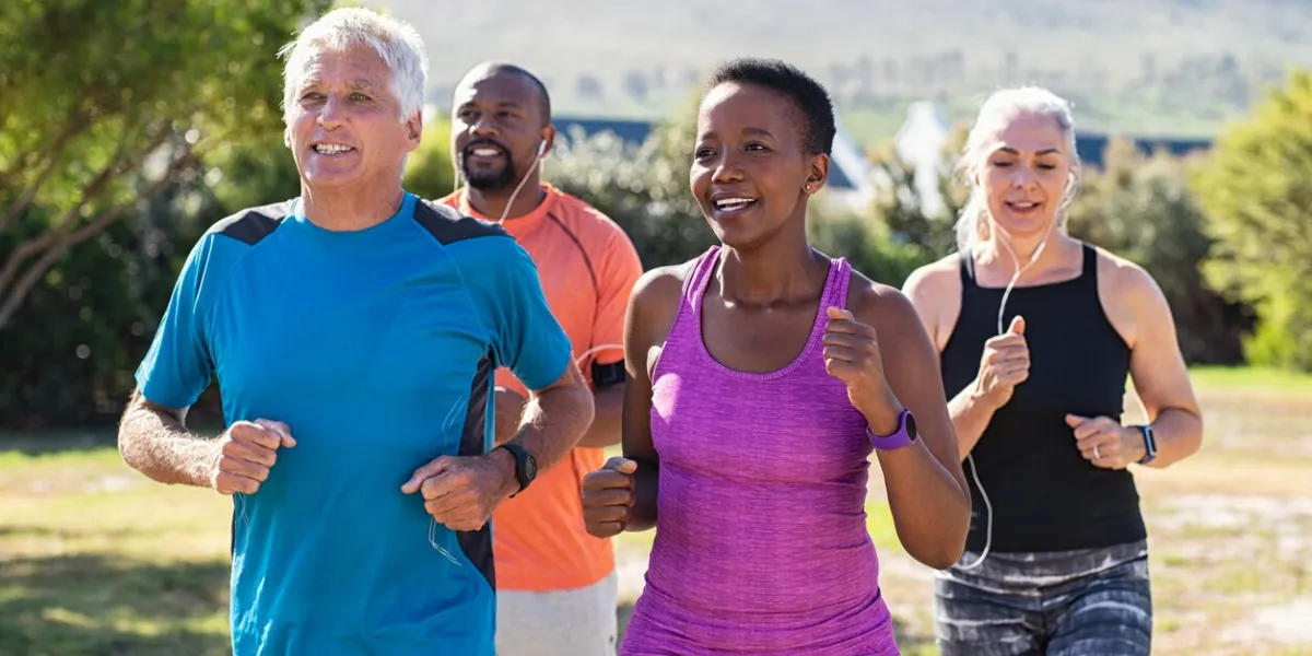 healthy group of mature people jogging on track at park happy senior couple running at park with african friends multiethnic middle aged friends exercising together outdoor