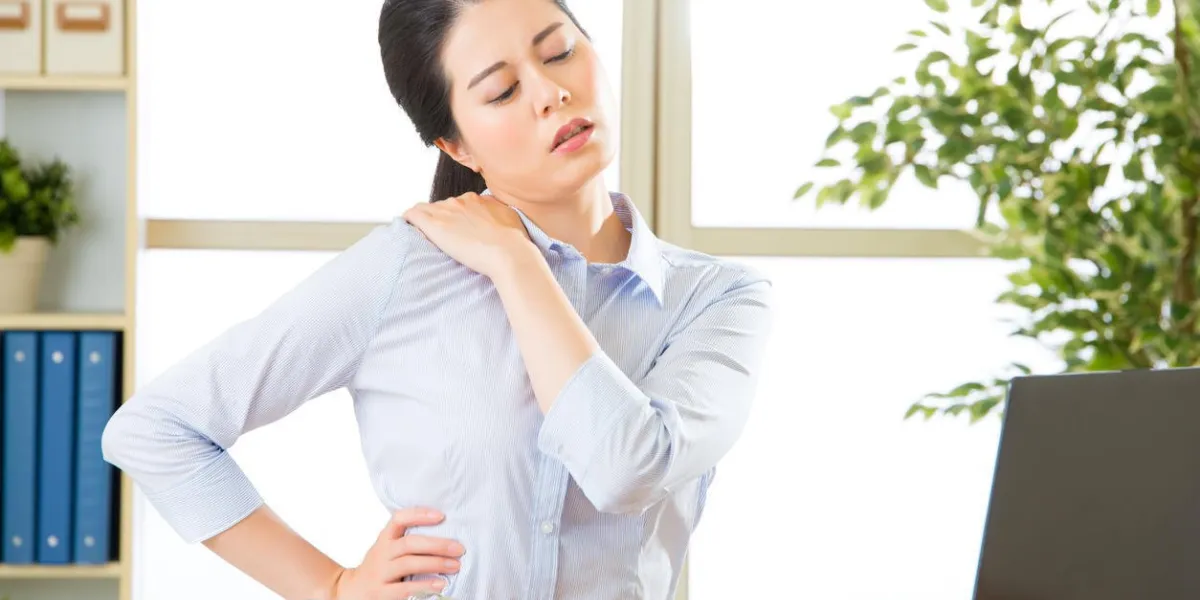 jeune femme d'affaires asiatique avec douleur dans les épaules au bureau