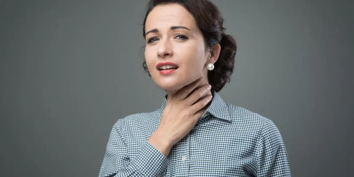 femme vintage avec mal de gorge touchant son cou