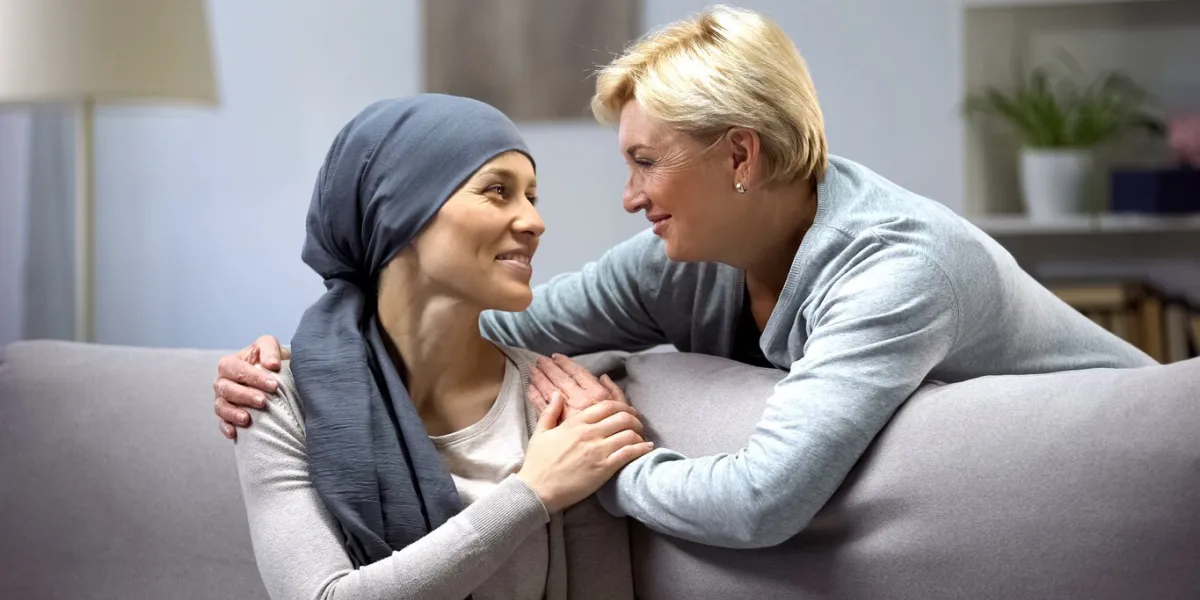 smiling woman with cancer hugging mother, hope and togetherness, remission