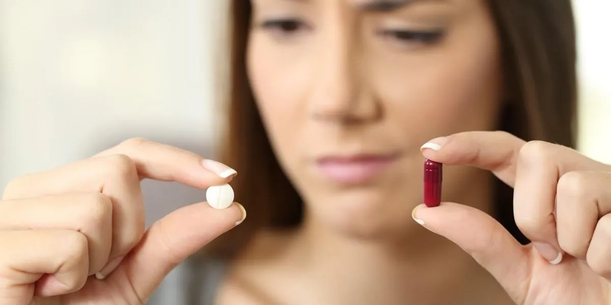 portrait d'une femme s'interrogeant sur la pilule ou la capsule dans un intérieur de maison