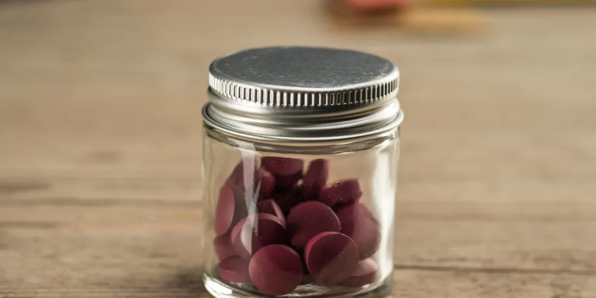 iron supplement pills in glass and metal container