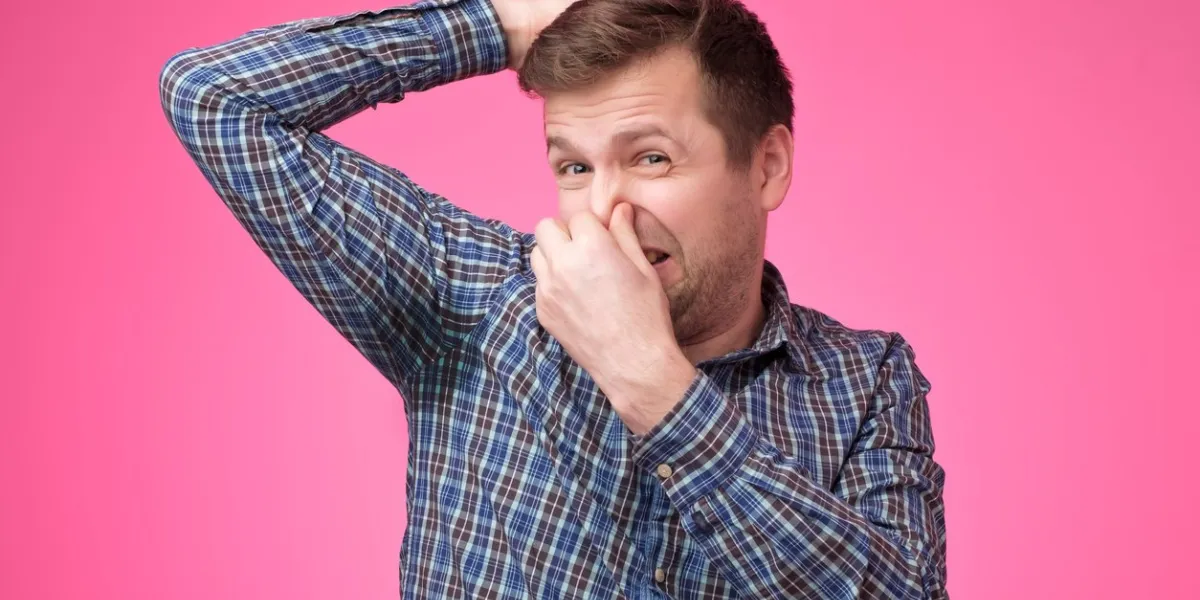 caucasian, young man is worried and shocked because of sweating stain problem with hyperhidrosis studio shot on pink background