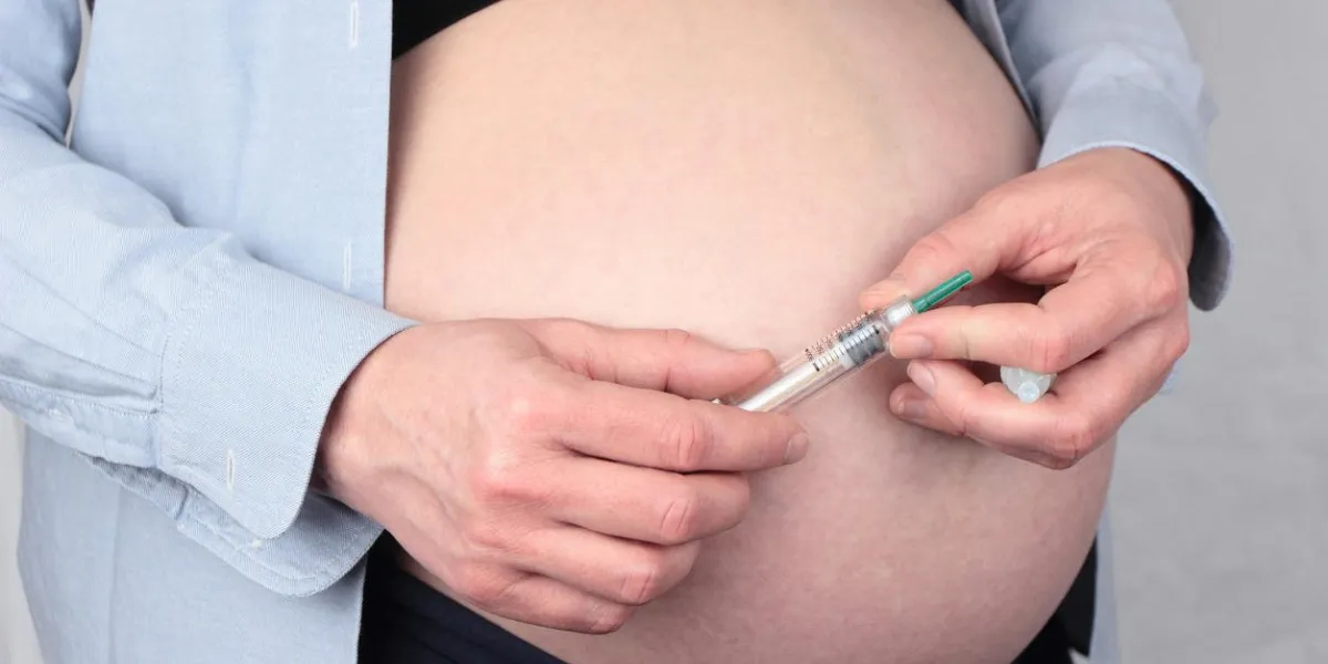 femme enceinte tenant le stylo d'injection