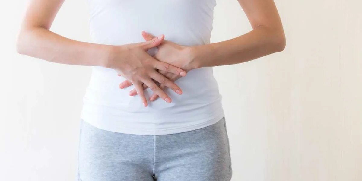 お腹をおさえる女性