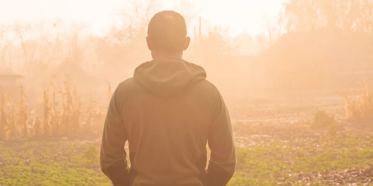 back portrait of a man enjoying a beautiful autumn foggy morning in the countryside