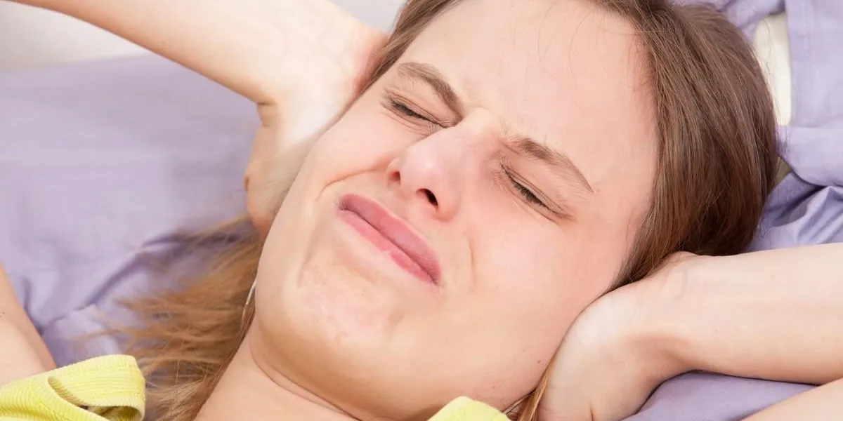 bruit et mal de tête pour une jeune femme dans son lit