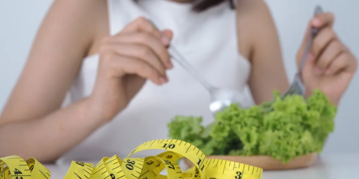 asian women are tired of eating vegetables using a fork of lettuce in the dish healthy food and diet concept