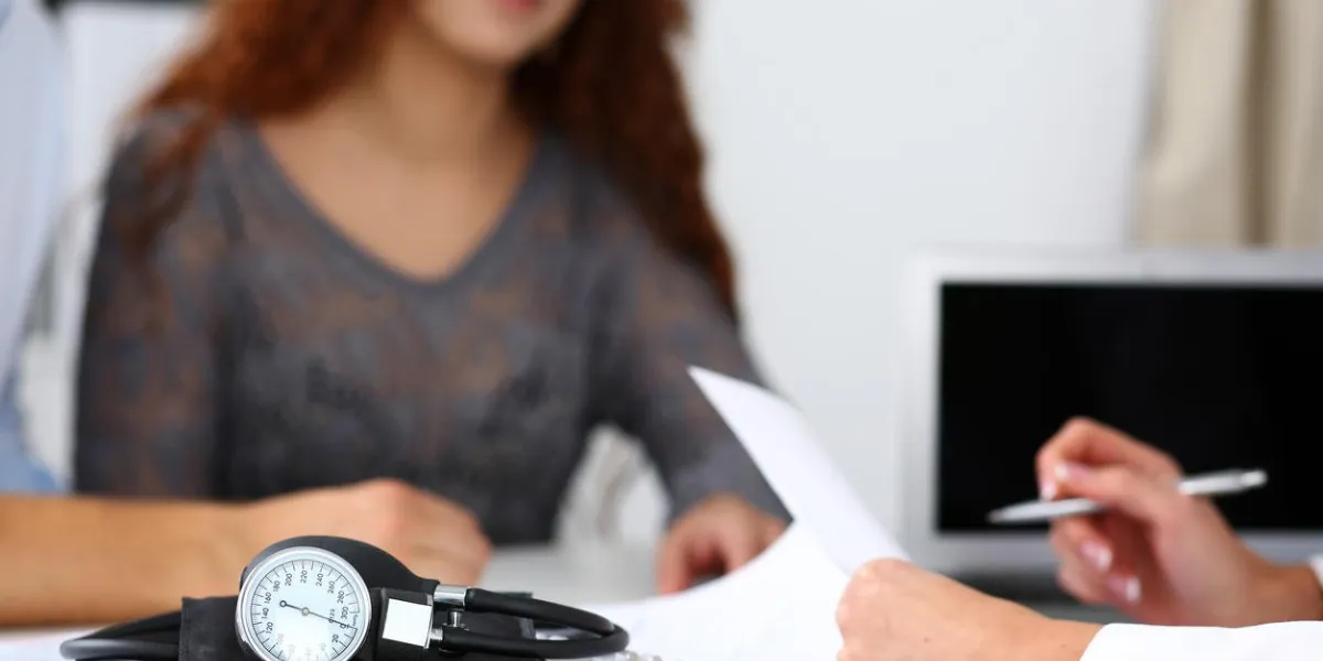 medical manometer lying on table while doctor consult young couple patients closeup motherhood and child delivery, new life or abortion, family therapeutist, hospital and clinic concept
