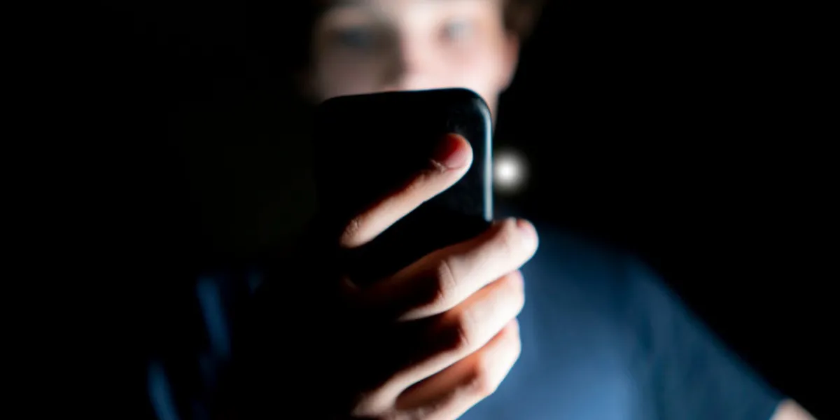 young attractive man use mobile phone late at night in a dark room b