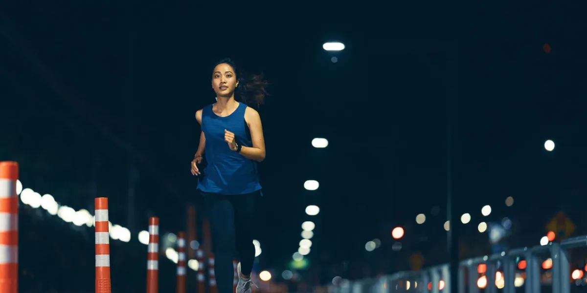 asian woman practicing running at night