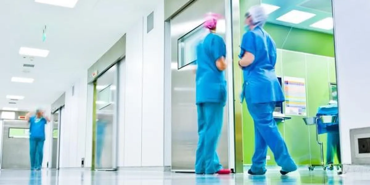 figures floues portant des uniformes médicaux dans le couloir de la chirurgie de l'hôpital