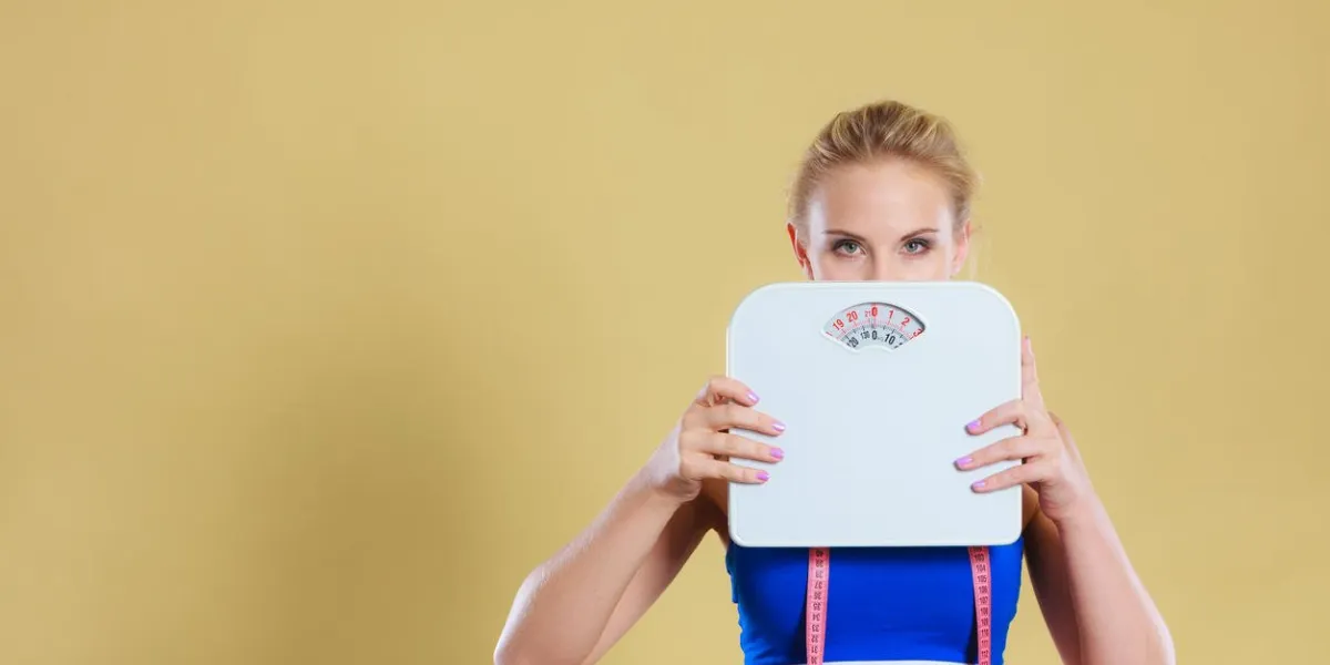 fille blonde triste frustrée couvrant son visage avec des échelles gain de poids, le temps pour amincir la perte de poids, régime