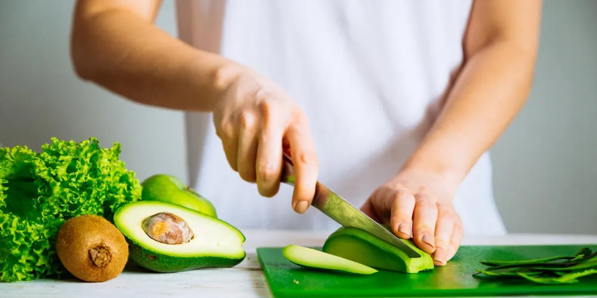 woman cut avocado healthy food concept ingredients for smoothies