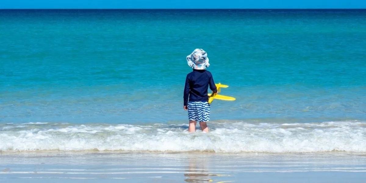child,playing,on,the,beach,wearing,wide,brimmed,hat,,rashie