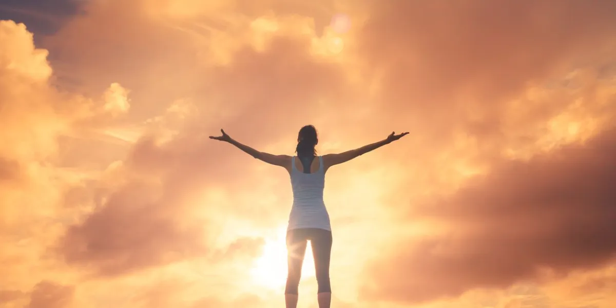 woman raising arms in a beautiful sunset