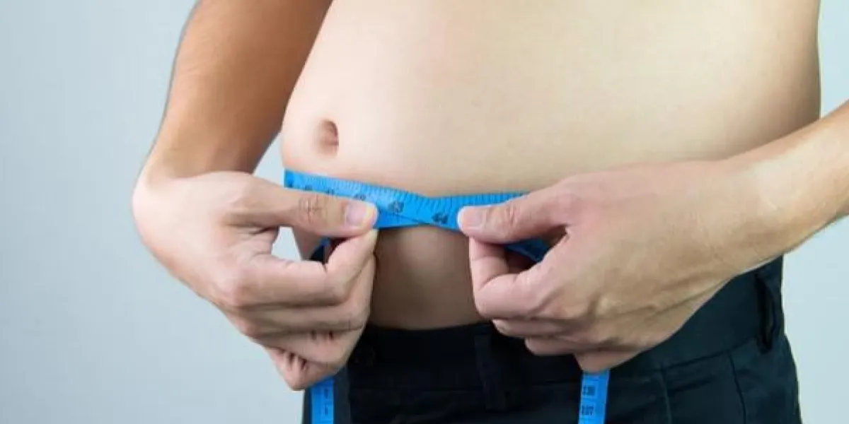 homme mesurant son ventre en utilisant un ruban à mesurer