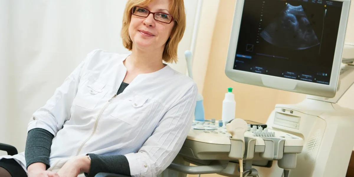 Épreuve d'échographie grossesse portrait de femme médecin gynécologue lors de l'examen des signes de la vie fœtale du patient avec le scanner