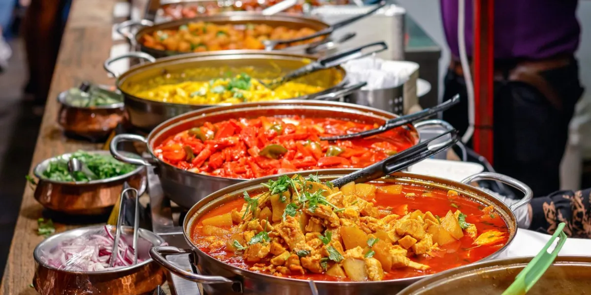 variety of cooked curries on display at camden market in london