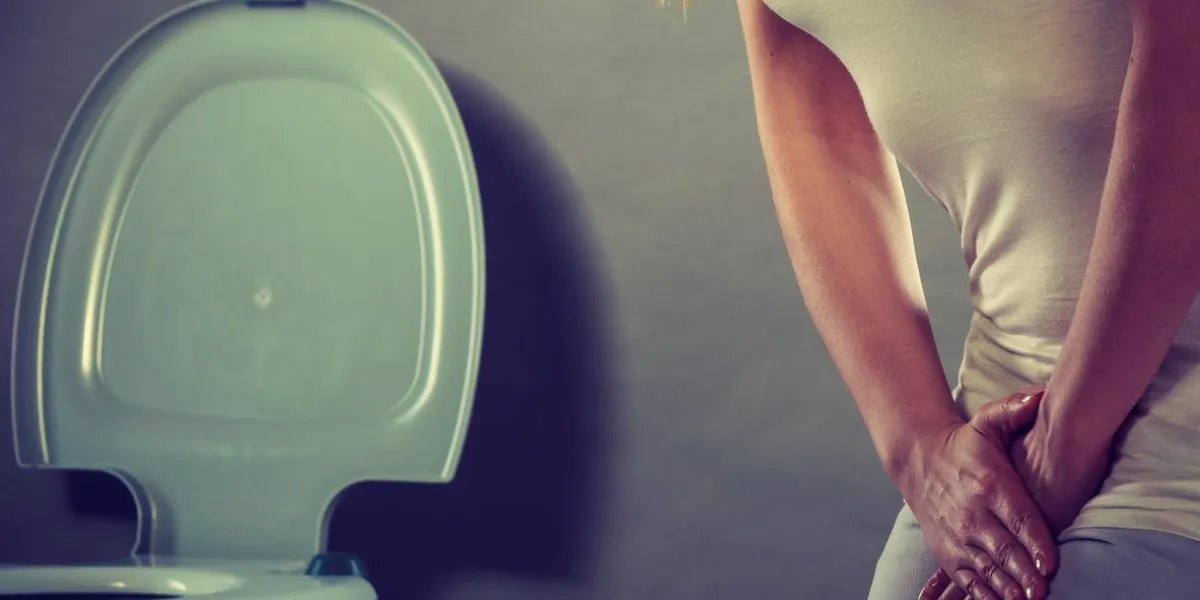 femme malade avec les mains tenant en appuyant sur son entrejambe bas de l'abdomen en face de la cuvette des toilettes problèmes médicaux, l'incontinence, le concept de soins de santé