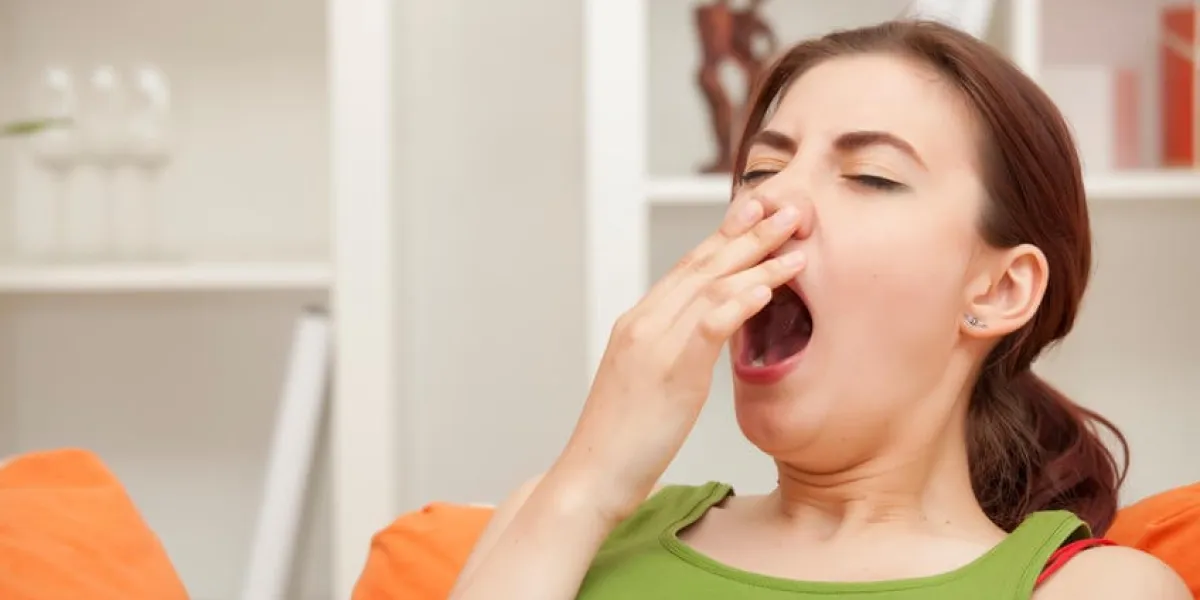 béant femme assise sur le canapé à la maison